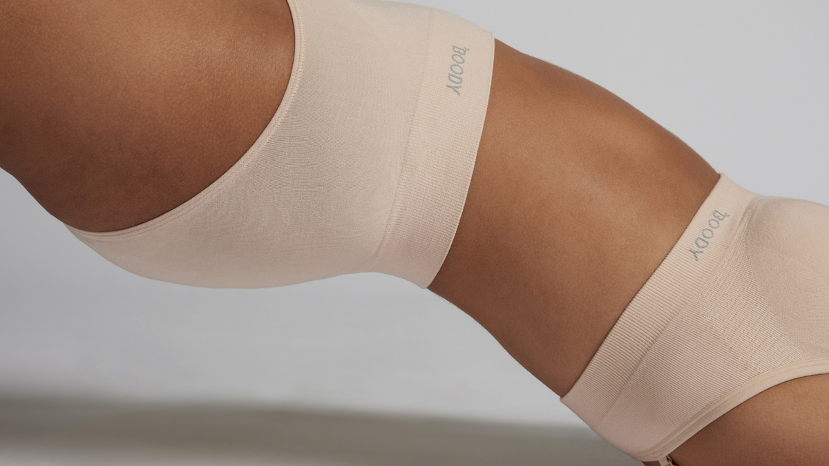 Close-up of a model wearing nude seamless underwear and a matching seamless bandeau-style bra, showcasing a smooth, minimalist fit against the skin.